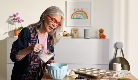 woman using a smart speaker while cooking