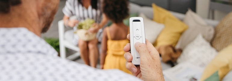 Man holding Somfy remote control